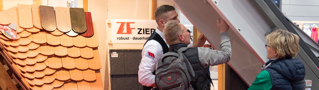 Ein Mann und eine Frau lassen sich von einem Dachdecker beraten.