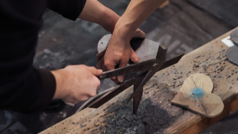 Zwei Jungs bearbeiten zusammen Holz