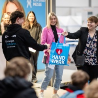 Mitarbeiter der Leipziger Messe halten einen Handwerk Beutel.