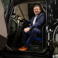 Ein Mann im Anzug sitzt in einem LKW