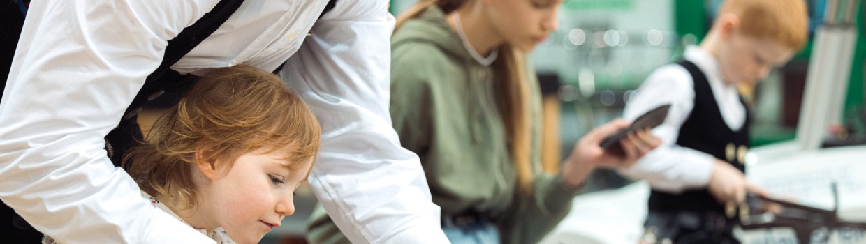 Ein Mann hilft einem Kind bei handwerklicher Arbeit.